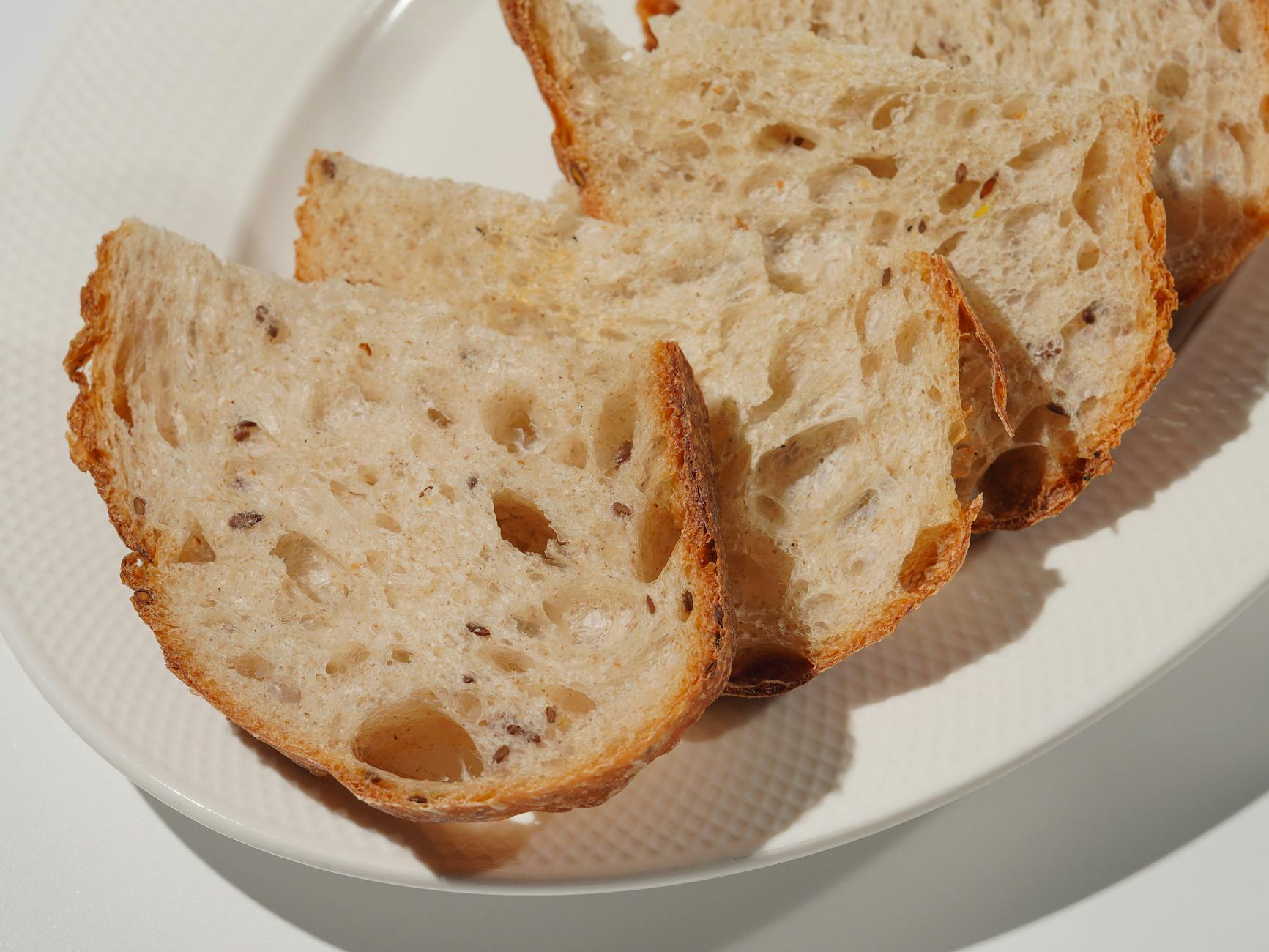 close up of sliced multigrain bread on plate